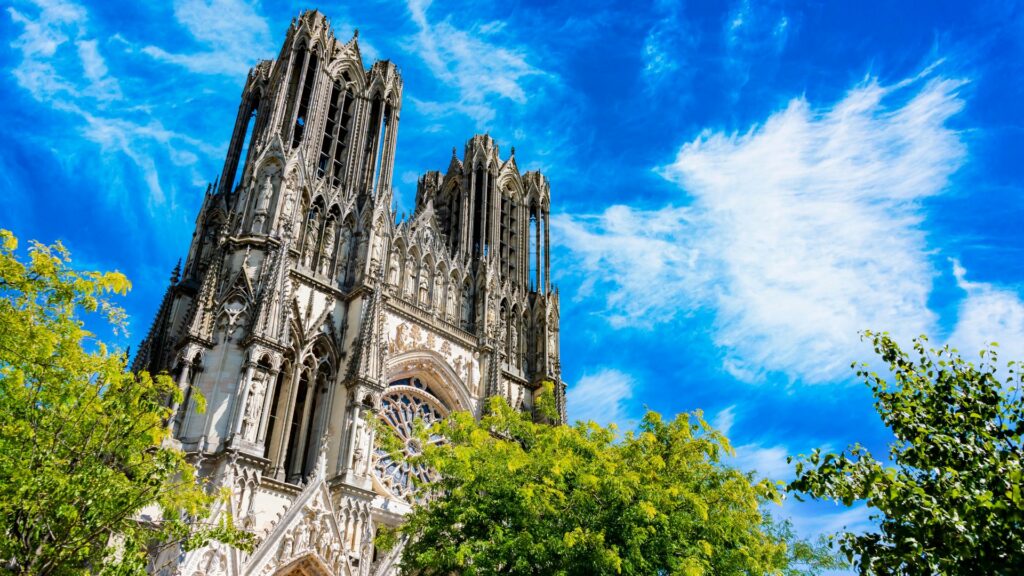 Façade de la cathédrale de Reims sous un ciel bleu éclatant.
